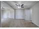 Spacious living room features neutral carpet, a ceiling fan, and doorways to adjacent rooms at 58 Knox Rd, Powder Springs, GA 30127