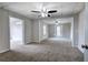 Open living room features neutral carpet, a ceiling fan, and doorways to adjacent rooms at 58 Knox Rd, Powder Springs, GA 30127