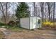 A simple metal shed with a door and window, surrounded by greenery and trees at 58 Knox Rd, Powder Springs, GA 30127