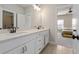 Bathroom featuring double vanity, white cabinets, and modern black hardware at 6180 Bellmoore Park Ln, Duluth, GA 30097