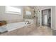 This bathroom features a tub, glass shower, and tile floors, with a window that brings plenty of natural light at 6180 Bellmoore Park Ln, Duluth, GA 30097