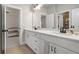 Elegant bathroom featuring double sinks, white cabinetry, and a large mirror, providing a bright and functional space at 6180 Bellmoore Park Ln, Duluth, GA 30097