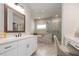 Bathroom showcases a double vanity with white countertops, modern fixtures, and a seamless glass shower with a tub at 6180 Bellmoore Park Ln, Duluth, GA 30097