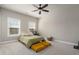 Spacious bedroom with carpet, natural light from windows, and a ceiling fan, offering a comfortable and serene atmosphere at 6180 Bellmoore Park Ln, Duluth, GA 30097