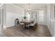 Elegant dining room with wainscoting detail, modern light fixture, and beautiful wood flooring at 6180 Bellmoore Park Ln, Duluth, GA 30097