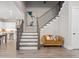 Grand entryway with staircase, modern art, and a cozy sitting area leading to the kitchen and dining spaces at 6180 Bellmoore Park Ln, Duluth, GA 30097