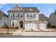 Charming home with a two-car garage, brick and siding facade, and an inviting front yard at 6180 Bellmoore Park Ln, Duluth, GA 30097