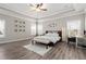 This is a spacious main bedroom with tray ceilings, multiple windows, wood-look flooring, and a ceiling fan at 6180 Bellmoore Park Ln, Duluth, GA 30097