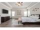 A main bedroom features beautiful wood-look floors, tray ceilings, many windows, and soft, neutral walls at 6180 Bellmoore Park Ln, Duluth, GA 30097