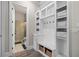 Mudroom with built-in storage, bench seating, and a view into an adjacent bathroom with a glass shower at 6180 Bellmoore Park Ln, Duluth, GA 30097