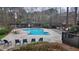Relaxing community pool area with lounge chairs, umbrellas, and outdoor seating amid lush greenery at 1804 Cumberland Se Ct, Smyrna, GA 30080