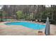 Inviting community pool with lounge chairs and shade umbrella near the tennis court at 1804 Cumberland Se Ct, Smyrna, GA 30080