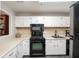 Modern kitchen with sleek black appliances, white cabinetry and a convenient window that overlooks the dining room at 1804 Cumberland Se Ct, Smyrna, GA 30080