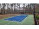 Community tennis court surrounded by trees offers a great place to play at 1804 Cumberland Se Ct, Smyrna, GA 30080