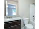 Well-lit bathroom featuring a granite countertop, dark wood cabinets, and a shower-tub combo at 3118 Old Covington Hwy, Covington, GA 30014