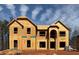 Two-story new construction home showcasing the facade with visible framing and arched entryway against a bright, partly cloudy sky at 3118 Old Covington Hwy, Covington, GA 30014
