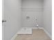 The spacious laundry room includes a shelf, washer and dryer hookups, and tiled floor at 3118 Old Covington Hwy, Covington, GA 30014