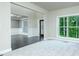 Bright living room boasting new carpet, large windows with wooded view, open space with neutral walls and dark hardwood floors at 3118 Old Covington Hwy, Covington, GA 30014
