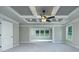 Primary bedroom features a tray ceiling, a fan, and large windows providing ample natural light, new carpet and neutral walls at 3118 Old Covington Hwy, Covington, GA 30014