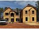 Two story new construction featuring an arched doorway and ladder to the roof at 3128 Old Covington Hwy, Covington, GA 30014