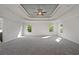 The large primary bedroom offers a tray ceiling, fan, and lots of natural light at 3128 Old Covington Hwy, Covington, GA 30014