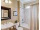 Cozy bathroom with shower-tub combo, tiled walls, and a framed mirror with a classic-style sink and fixtures at 5732 Ashleigh Walk Dr, Suwanee, GA 30024