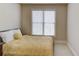 Cozy bedroom featuring a window providing natural light and a comfortable bed with a stylish yellow cover at 5732 Ashleigh Walk Dr, Suwanee, GA 30024