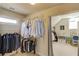 Well-organized walk-in closet with hanging racks and a glimpse into an adjacent dressing area with natural light at 5732 Ashleigh Walk Dr, Suwanee, GA 30024
