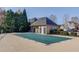 A neighborhood pool with a green cover and a pool house is surrounded by trees at 5732 Ashleigh Walk Dr, Suwanee, GA 30024