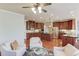 Open concept kitchen and living room with wood floors, cherry cabinets, an island, and modern furnishings at 5732 Ashleigh Walk Dr, Suwanee, GA 30024