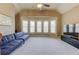Spacious living room featuring a wall of windows, neutral carpet, and a ceiling fan for added comfort at 5732 Ashleigh Walk Dr, Suwanee, GA 30024