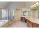 Spa-like main bathroom with double vanities, a glass shower, and soaking tub at 5732 Ashleigh Walk Dr, Suwanee, GA 30024