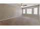 Large bedroom features neutral carpet, ceiling fan, and a bank of windows at 600 Canterbury Ln, Lawrenceville, GA 30046