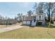 Exterior view of a two-story home featuring a two-car garage and nice lawn with a building in the background at 600 Canterbury Ln, Lawrenceville, GA 30046