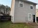 Side view of the backyard featuring a well-maintained lawn, partial fence, and gray siding at 115 Glynn Addy Dr, Stockbridge, GA 30281