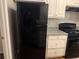 Compact kitchen with a black refrigerator and stove, plus white cabinets at 115 Glynn Addy Dr, Stockbridge, GA 30281
