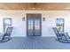 Inviting front porch featuring a wood ceiling, rocking chairs, and a stylish double door entry at 2418 Claude Brewer Rd, Loganville, GA 30052