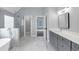 Bathroom featuring marble floors, a glass shower, a free-standing tub, and gray cabinets at 2784 Hilson Commons, Decatur, GA 30034