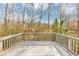 A spacious gray deck overlooks the wooded backyard with a wooden railing for enhanced enjoyment at 2784 Hilson Commons, Decatur, GA 30034