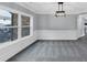 Bright living room with carpet, chair rail, crown molding, and a modern light fixture with a large window at 2784 Hilson Commons, Decatur, GA 30034