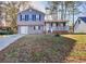 Split-level home with a gray exterior, a driveway, and a covered front porch with multiple windows at 4185 Duesenberg Dr, Tucker, GA 30084