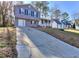 Split-level home showcasing the driveway and a covered front porch with railing at 4185 Duesenberg Dr, Tucker, GA 30084