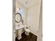 Charming half bath features a pedestal sink, dark floors and decorative mirror at 501 Crescent Woode Dr, Dallas, GA 30157