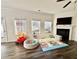 Bright living room featuring a fireplace, large windows, and dark wood flooring at 501 Crescent Woode Dr, Dallas, GA 30157