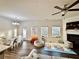 Open living space with ceiling fan, fireplace, multiple windows, and adjacent kitchen and dining areas at 501 Crescent Woode Dr, Dallas, GA 30157