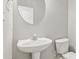Powder room featuring a toilet and pedestal sink at 2297 Elmbridge Rd, Buford, GA 30519