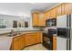 Kitchen area showcasing wooden cabinets, a black appliance suite, and neutral countertops at 2297 Elmbridge Rd, Buford, GA 30519