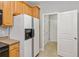 Well-lit kitchen with wood cabinets and white refrigerator with water dispenser at 2297 Elmbridge Rd, Buford, GA 30519