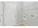 Laundry room with white door, gray walls, and shelving above appliances at 2297 Elmbridge Rd, Buford, GA 30519