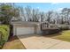 Exterior view of brick home, showcasing driveway and a one-car garage at 4063 Elmscourt Dr, Stone Mountain, GA 30083